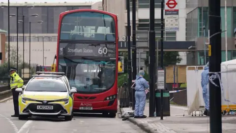 PA Media Forensic investigators at the scene where a 15-year-old girl was stabbed to death in Croydon, south London on Wednesday morning