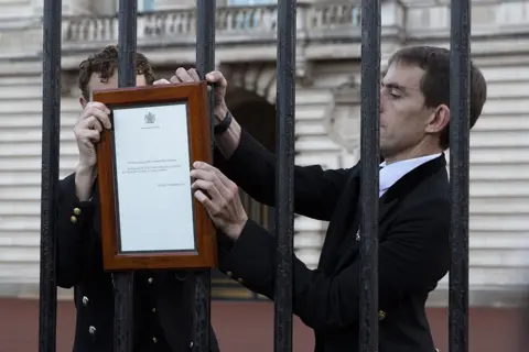 Tom Pilston A member of royal household staff posts a notice on the gates of the Buckingham Palace in London announcing the death of Queen Elizabeth I