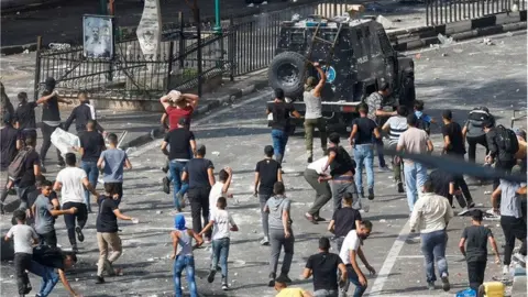 Reuters Palestinians chase police vehicle in Nablus (20/09/22)