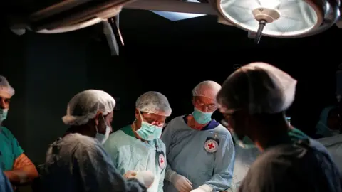 Reuters British vascular surgeon John Wolfe, who was invited to Gaza by the International Committee of the Red Cross (ICRC), performs a surgery for a wounded Palestinian in the operating room in a hospital in Gaza City April 25, 2018