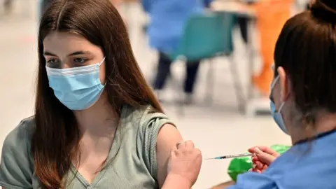 Getty Images Teenager Katie Moore receives a Covid-19 vaccine at a vaccination centre in Barrhead, south of Glasgow on August 9, 2021,