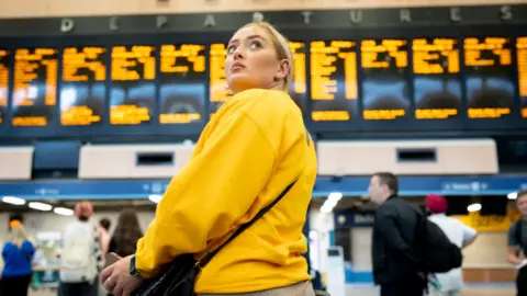 Getty Images Woman waiting at station