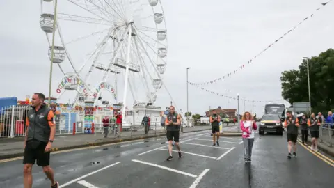 Getty Images Angie Comerford runs with the baton along South Shields seafront