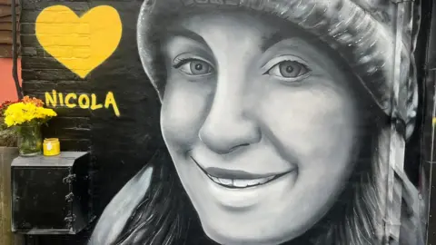 BBC A mural of Nicola Bulley painted at the One Stop shop in South Woodham Ferrers