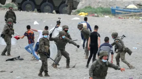 Reuters A Spanish legionnaire hits a Moroccan citizen at El Tarajal beach, near the fence between the Spanish-Moroccan border