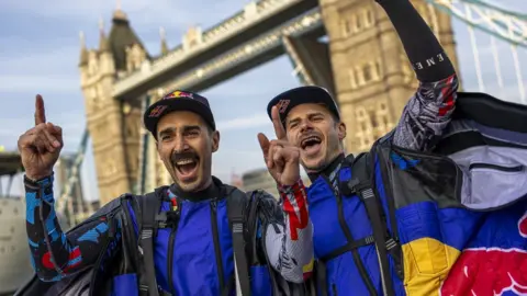 Joerg Mitter/RedBull/PA Marco Waltenspiel and Marco Fürst in their suits, cheering, with their hands in the air