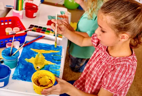 targovcom/Getty Images Child painting with yellow