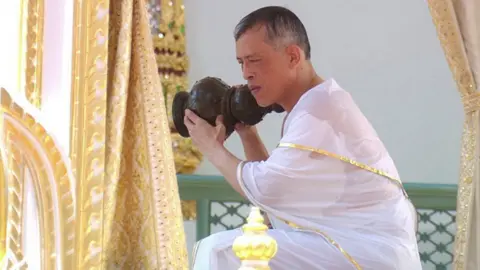 Getty Images King Maha Vajiralongkorn, sat down, pouring holy water over his shoulders
