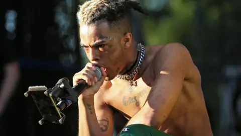 Alamy XXXTentacion performing on stage topless at outdoor event