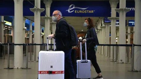 AFP Passengers wearing facemasks at the Eurostar terminal at St Pancras station in London