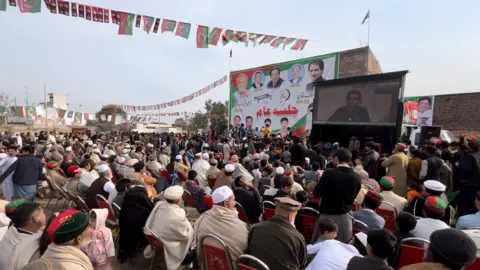 BBC People at a rally for Atif Khan in Khyber Pakhtunkhwa watch him speak on a big screen on the back of a truck 3 Feb 2024