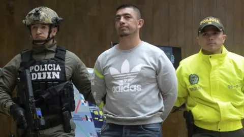 AFP In this file photo taken on April 11, 2017 Colombian Police officers escort Ecuadorean Washington Prado Alava aka "Gerald" (C), during a press conference at the police headquarters in Bogota, Colombia.