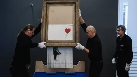 Getty Images Banksy's Girl with Balloon after the canvas passed through a hidden shredder.