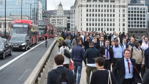 Getty Images Commuters walk across London Bridge