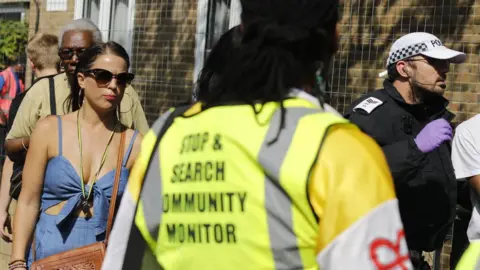 Getty Images A stop and search community monitor watches police stop someone