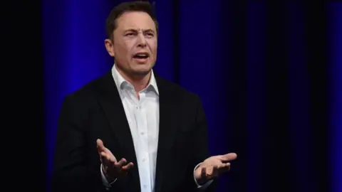 Getty Images Elon Musk looks annoyed and gesticulates with his hands