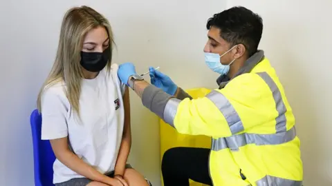 PA Media Young person being vaccinated