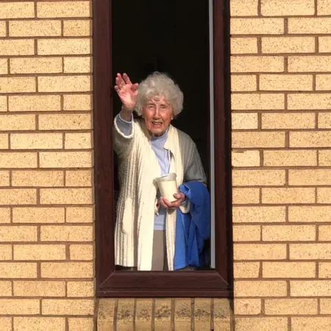 Shona Martin Lady waving at window
