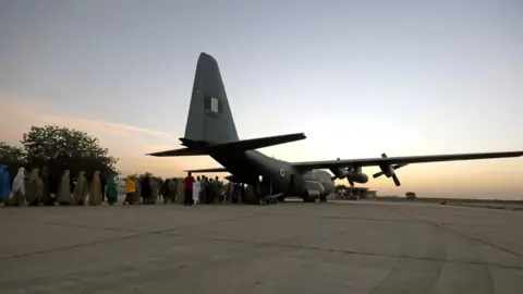 Reuters Dozens of kidnapped girls from Dapchi, northern Nigeria lined up waiting to board a plane at an air force base Maiduguri, Nigeria.