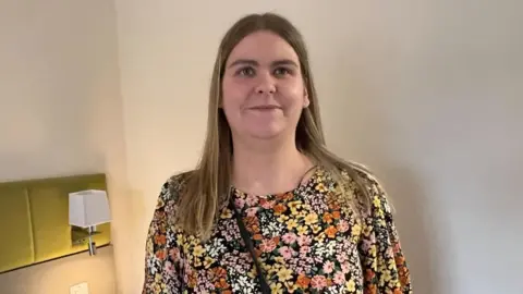 Kate Bradbrook/BBC Woman with long fair hair and a patterned dress