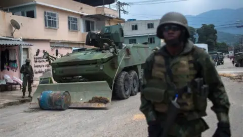 AFP Soldiers of the Armed Forces, backed by armoured vehicles, aircraft and heavy engineering equipment, clear a road blockade as they take part in an operation in the violence-plagued favela of Vila Kennedy, in Rio de Janeiro, Brazil, on March 7, 201