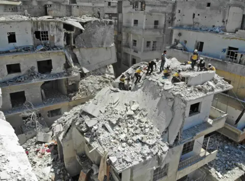 Getty Images White helmets to try rescue someone from a damaged building in Idlib province