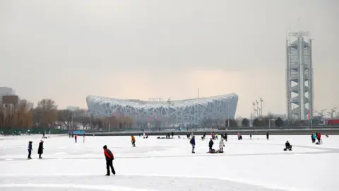 Reuters People skate on the frozen canal in front of the Birds Nest national stadium in Beijing in January 2022