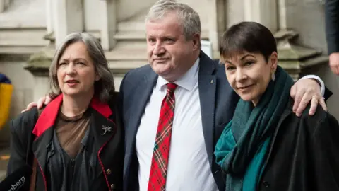 Barcroft Media/Getty Images Liz Saville Roberts, with leader of the SNP in the House of Commons Ian Blackford and Green Party MP Caroline Lucas speak to the media outside the Supreme Court following the verdict on the legal challenge against prorogation of Parliament on 24 September, 2019 in London, England.