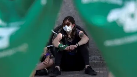 EPA Women participate in a protest in front of the headquarters of the Universidad Catolica de Chile in Santiago to demands the legalisation of abortion, Chile, 13 January 2021.