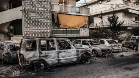 Getty Images Damaged vehicles in Rafina, Greece