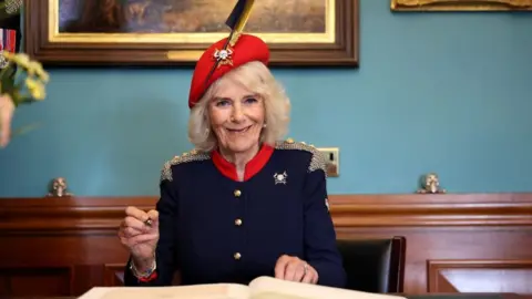 PA Media Queen Camilla signs the visitor book