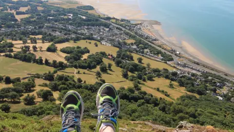 Alan Jones Alan's feet appear in the bottom of the picture which looks out high over the community below and the shoreline