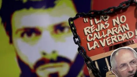 Reuters A man holds a sign with a portrait of opposition leader Antonio Ledezma in front of a wall with a portrait of opposition leader Leopoldo Lopez during a news conference