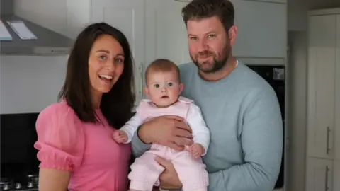 Carly Beasley/Brain Tumour Research) Carly Beasley with her husband Kris and daughter Ivy