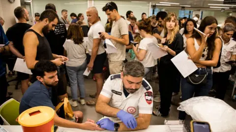 Getty Images Israelis line up to donate blood in Tel Aviv