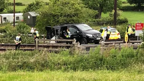 BBC A black van was struck by a train near Welshpool