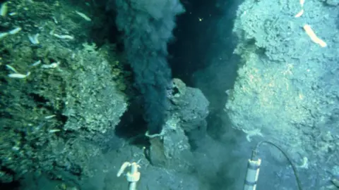 Science Photo Library View from a deep sea vehicle of the billowing black "smoke" being emitted by a hydrothermal vent on the ocean floor. Known as a "black smoker", this sulphurous mineral-rich fluid pours out of a sulphur-encrusted mound or chimney.