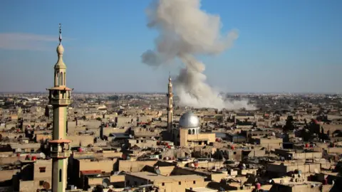 AFP Smoke rises from the town of Misraba following a reported government air strike (19 February 2018)