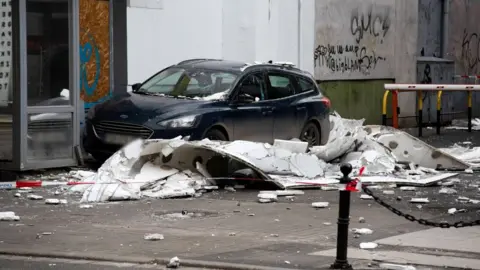 EPA A car surrounded by fallen debris in Poznan