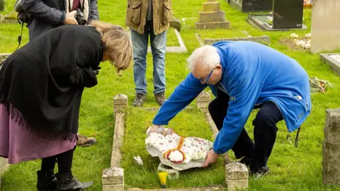 Dave Hanks A wreath being put on the tailor's grave