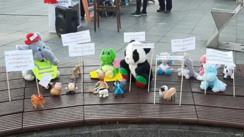 Gerila Soft toys arranged on a bench with protest slogans in Banja Luka