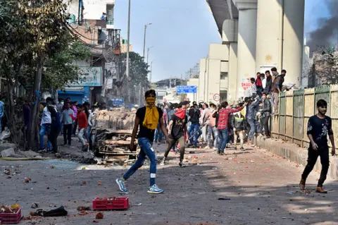 Getty Images Protesters seen during clashes between a group of anti-CAA protestors and supporters of the new citizenship act, near Maujpur and Jaffrabad metro station on February 24, 2020 in New Delhi