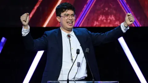 Getty Images Phil Wang in a celebratory pose at the podium