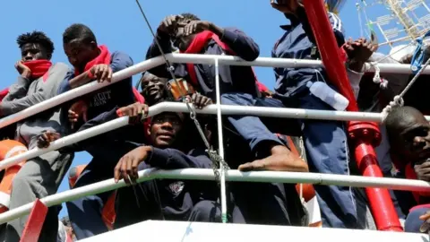 Reuters Migrants wait to disembark as they arrive at the Crotone harbour, Italy. Photo: 21 June 2017