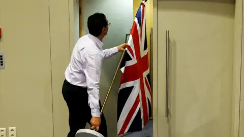 Reuters Brussels official carrying UK flag, 20 Jul 17