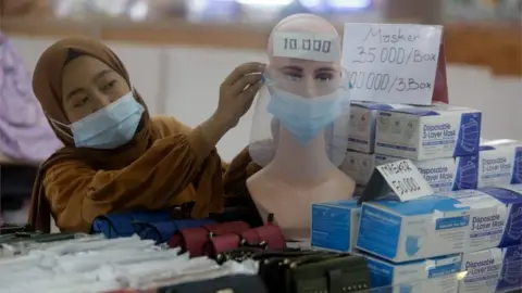 EPA A vendor arranges a mask attached to a mannequin at a shopping mall in Jakarta, Indonesia, 04 January 2021.