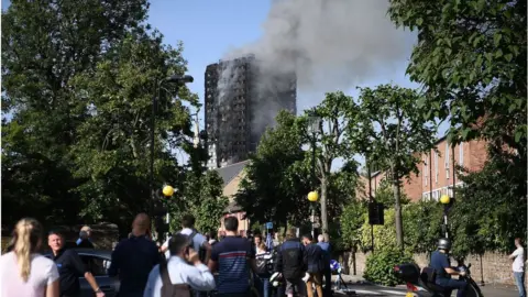 Getty Images People look at the fire