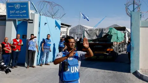 Reuters A UN worker assists aid trucks arriving into at a storage facility on 21 October