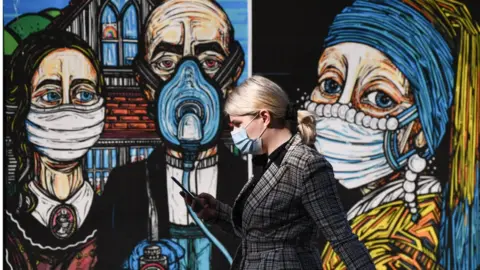 Getty Images Members of the public walk past coronavirus posters in the Merchant City on September 18, 2020 in Glasgow,