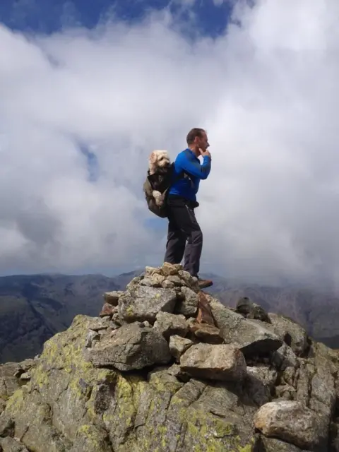 Hook News Monty in a backpack on Carlos' back while on a walk